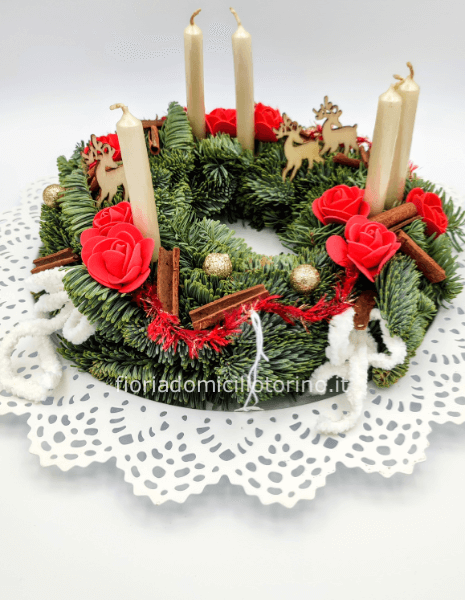 Ghirlanda/centrotavola con 5 candele bianche, roselline rosse, renne e guarnizione natalizie.